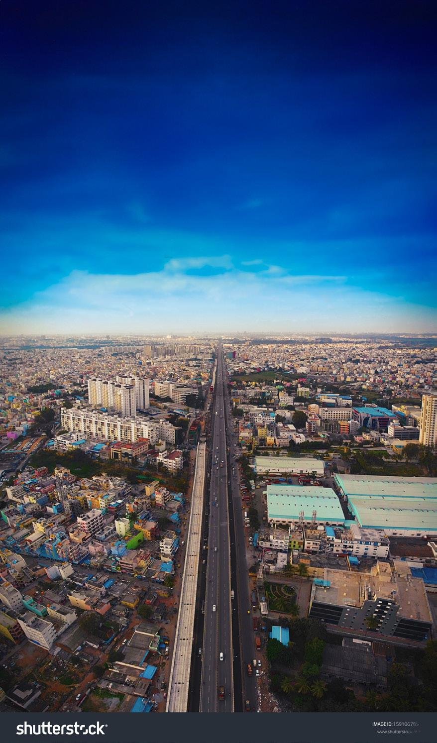 Three modern high-rise buildings with glass balconies and landscaped area in front
